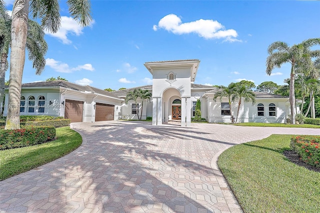 mediterranean / spanish house featuring a front yard and a garage