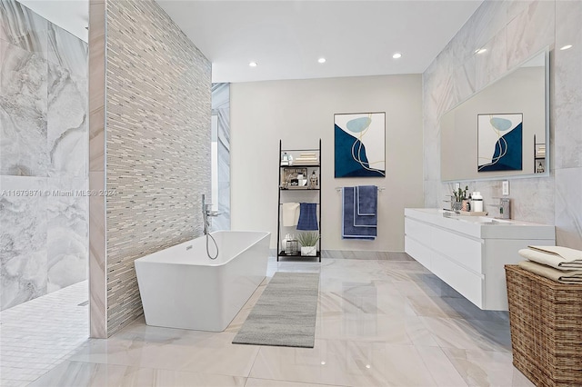 bathroom with vanity, tile walls, and shower with separate bathtub