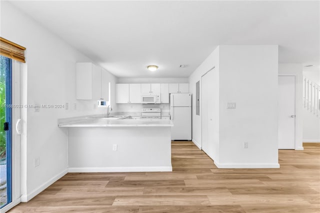 kitchen featuring white appliances, sink, kitchen peninsula, light hardwood / wood-style floors, and white cabinets