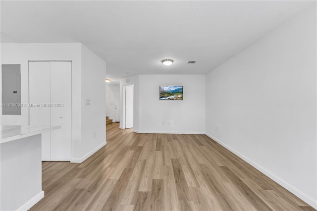 unfurnished living room featuring light hardwood / wood-style flooring and electric panel