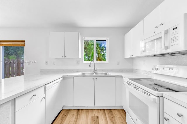 kitchen with white cabinetry, sink, light wood-type flooring, and white appliances