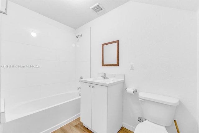 full bathroom featuring toilet, tiled shower / bath combo, hardwood / wood-style flooring, and vanity