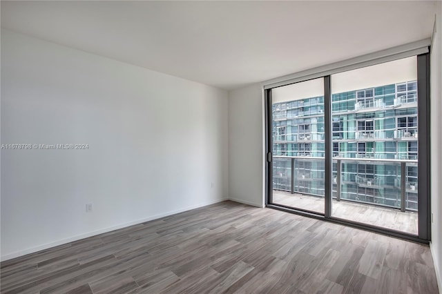 spare room with wood-type flooring and floor to ceiling windows