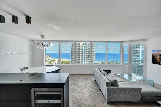 living room featuring a chandelier, wine cooler, and light parquet floors