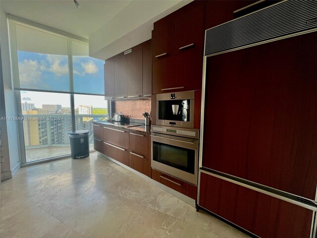 kitchen featuring black cooktop, tasteful backsplash, stainless steel double oven, and paneled fridge