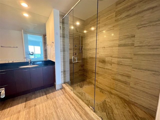 bathroom with a shower with door, vanity, and hardwood / wood-style floors