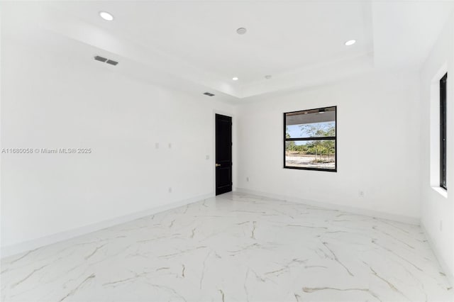 unfurnished room featuring a tray ceiling