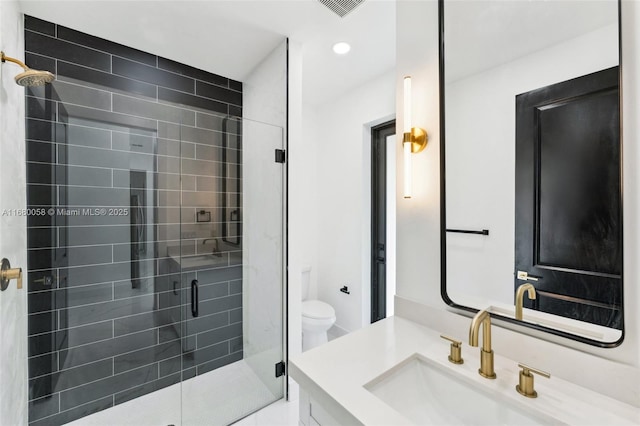 bathroom with vanity, an enclosed shower, and toilet