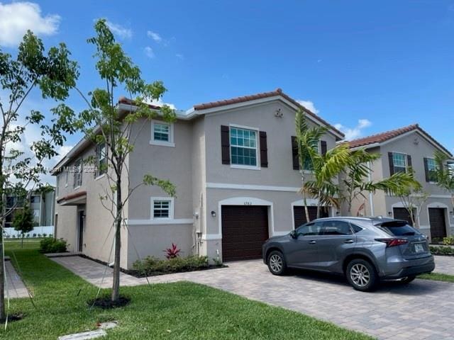 mediterranean / spanish-style house featuring a front yard and a garage