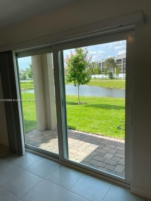 entryway with a water view, plenty of natural light, and tile patterned flooring