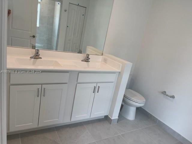 bathroom featuring vanity, toilet, and tile patterned flooring