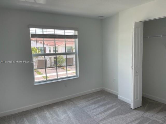 unfurnished bedroom featuring a closet, multiple windows, and carpet floors