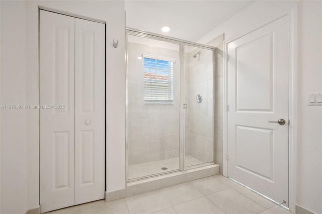 bathroom with tile patterned flooring and a shower with shower door