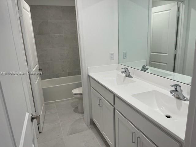 full bathroom featuring tiled shower / bath, vanity, and toilet