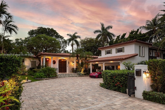 mediterranean / spanish house featuring stucco siding and a tiled roof