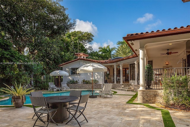 view of patio featuring an outdoor pool, outdoor dining space, and a ceiling fan