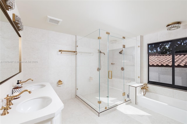 2616 Acacia Ct, Fort Lauderdale, FL 33301 - bathroom with tile walls, a garden tub, a stall shower, double vanity, and tile patterned flooring