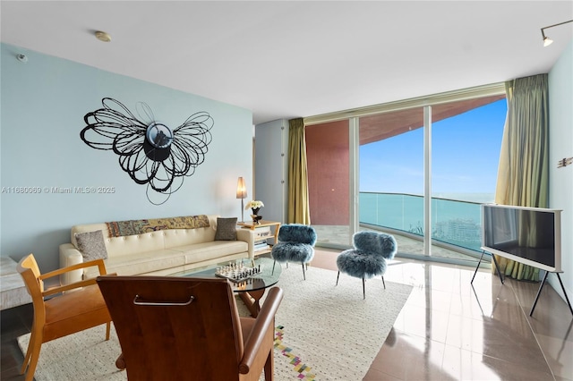 living room featuring a water view and a wall of windows