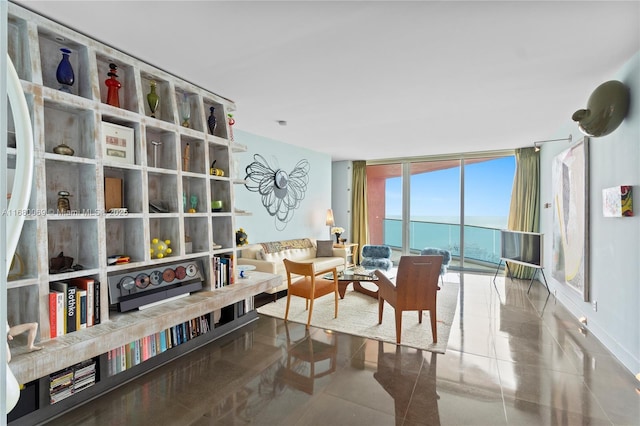 living area with tile patterned floors, expansive windows, and a water view