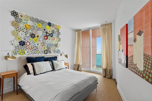 carpeted bedroom featuring access to exterior, a wall of windows, and a water view