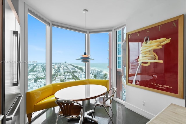 tiled dining area featuring a water view and a wall of windows