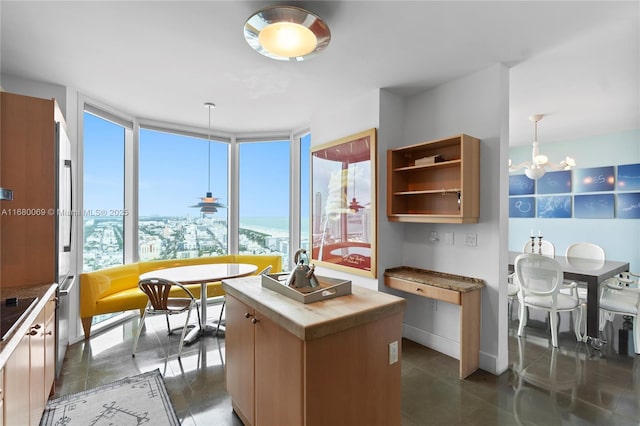 kitchen featuring wooden counters, pendant lighting, a center island, and expansive windows