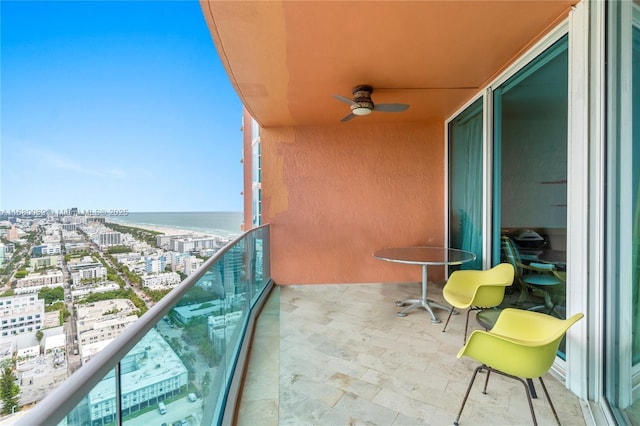 balcony featuring ceiling fan and a water view