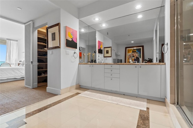 bathroom with vanity and a shower with door