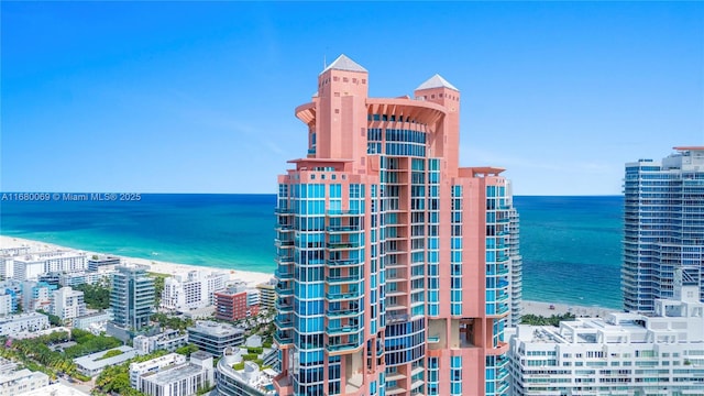 view of building exterior with a water view and a view of the beach