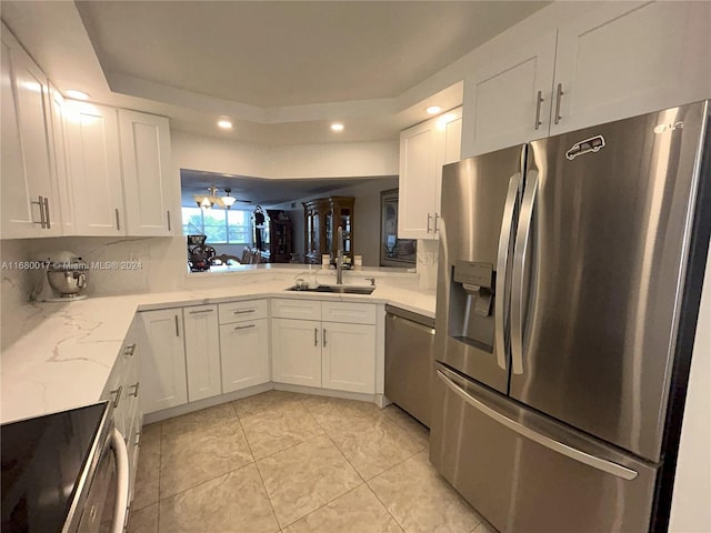 kitchen featuring sink, white cabinetry, light tile patterned floors, appliances with stainless steel finishes, and light stone counters