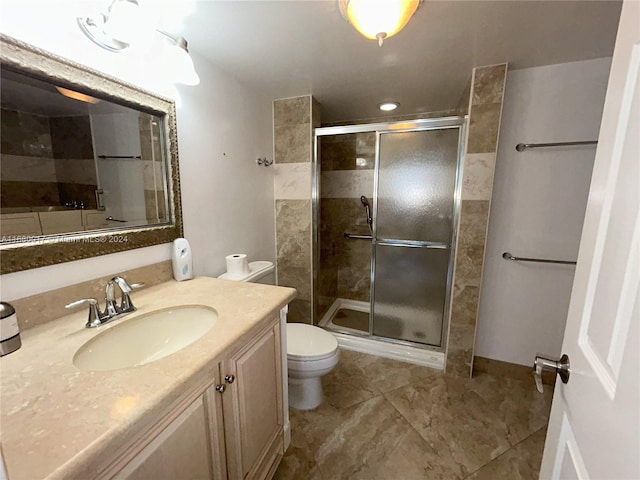 bathroom featuring vanity, toilet, and an enclosed shower