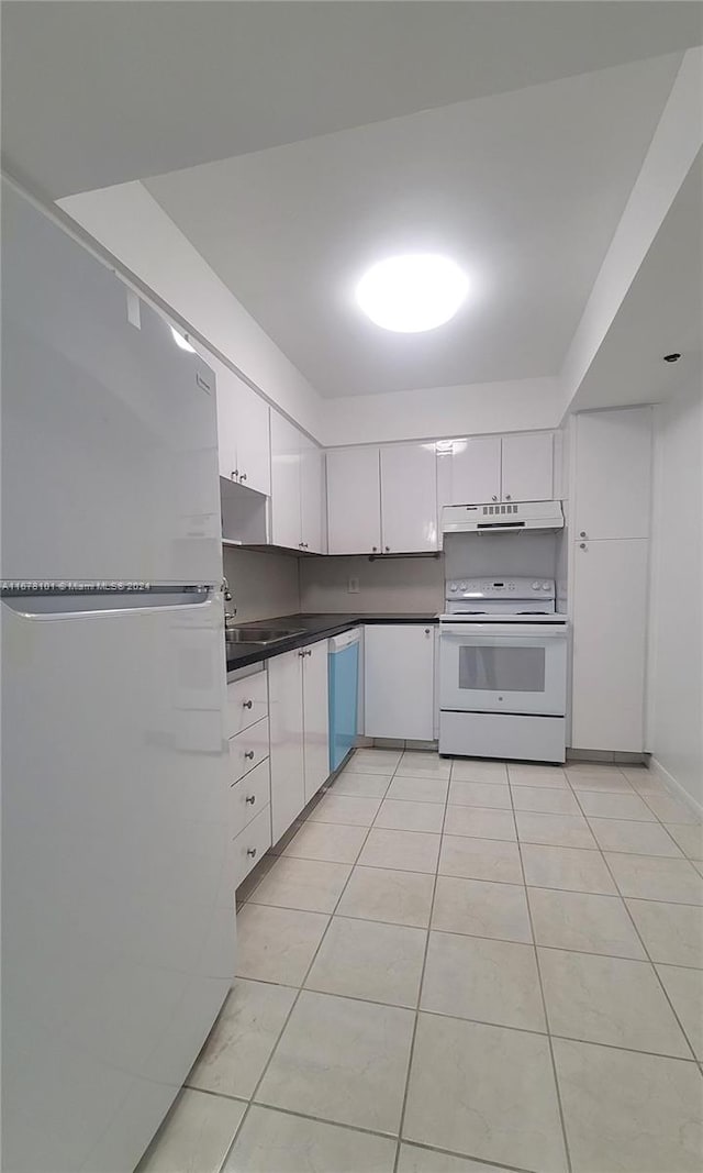 kitchen featuring light tile patterned floors, white cabinets, and white appliances