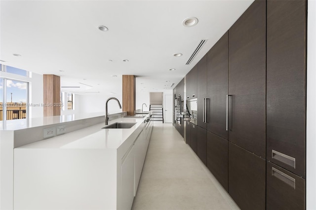 55 Merrick Way Unit 808, Coral Gables, FL 33134 - kitchen featuring a sink, modern cabinets, a large island with sink, light countertops, and recessed lighting