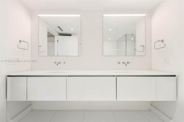 bathroom featuring tile patterned flooring, vanity, and a shower with shower door