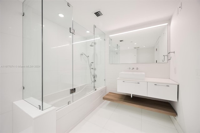 bathroom with tile patterned flooring, vanity, and enclosed tub / shower combo