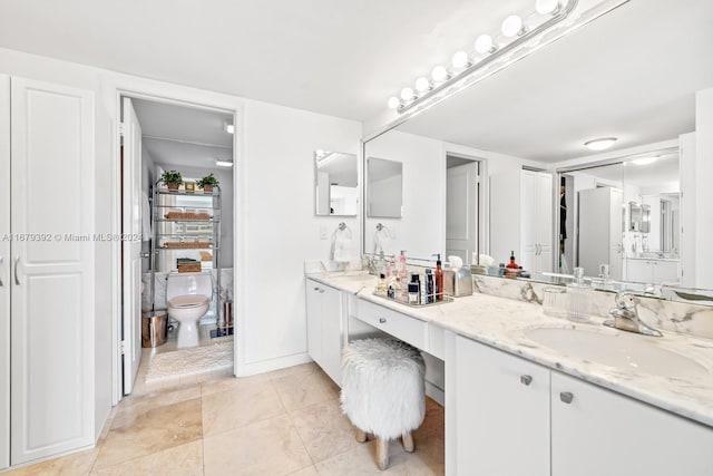 bathroom featuring vanity, toilet, and tile patterned flooring