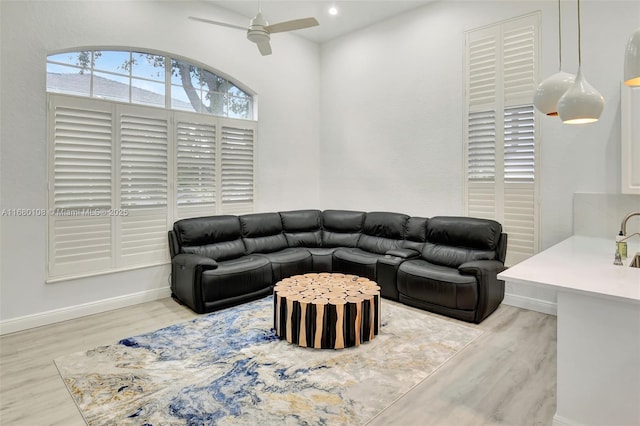 living room with ceiling fan and light hardwood / wood-style floors