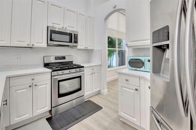 kitchen featuring white cabinetry, stainless steel appliances, and light hardwood / wood-style floors