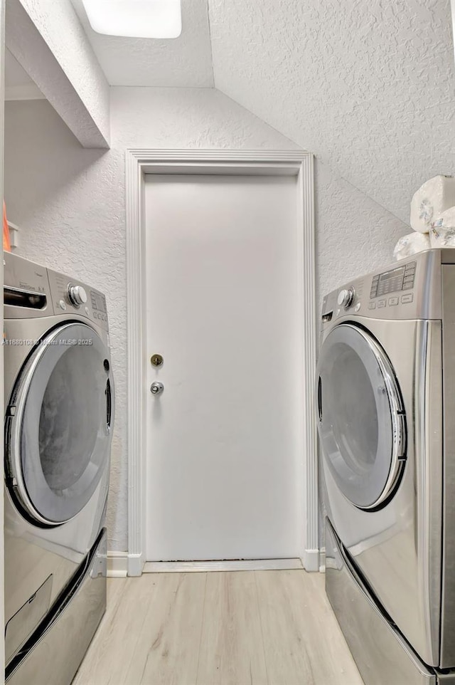 washroom with independent washer and dryer and light wood-type flooring