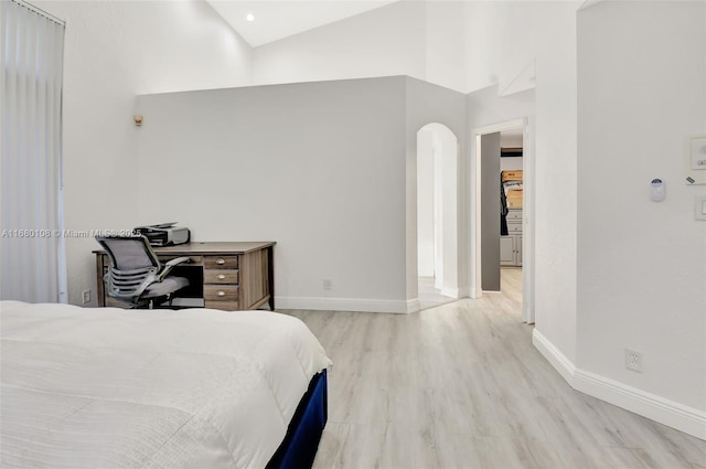 bedroom with high vaulted ceiling and light hardwood / wood-style floors