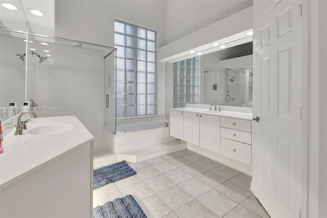 bathroom with tile patterned floors, vanity, shower with separate bathtub, and a wealth of natural light