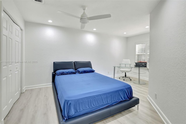 bedroom with ceiling fan, light hardwood / wood-style flooring, and a closet