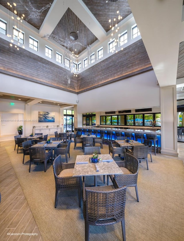 dining space featuring a towering ceiling and a notable chandelier