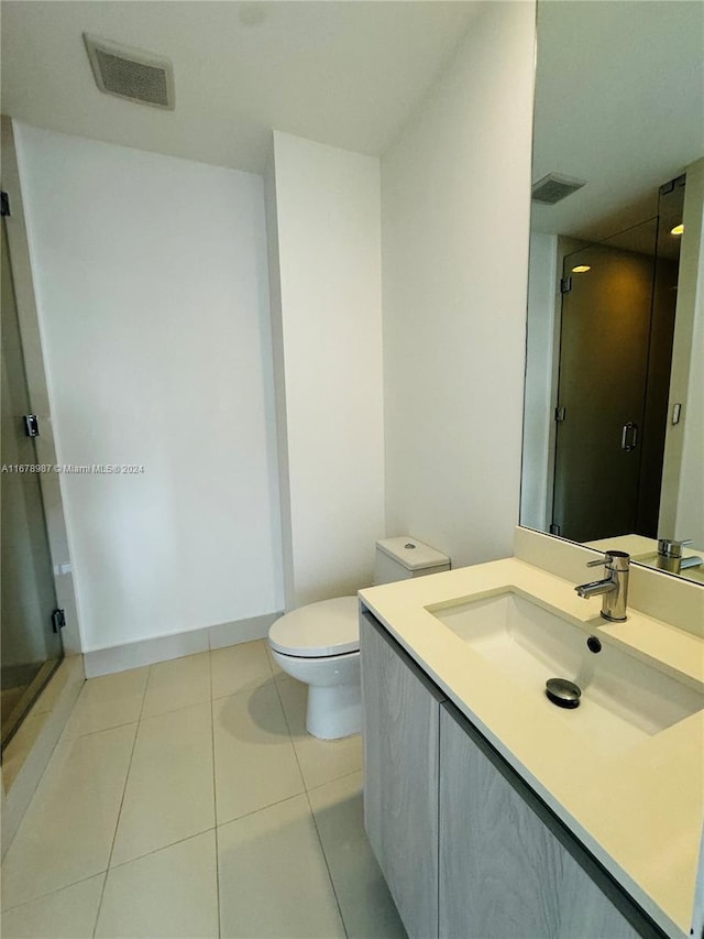 bathroom featuring walk in shower, vanity, toilet, and tile patterned floors