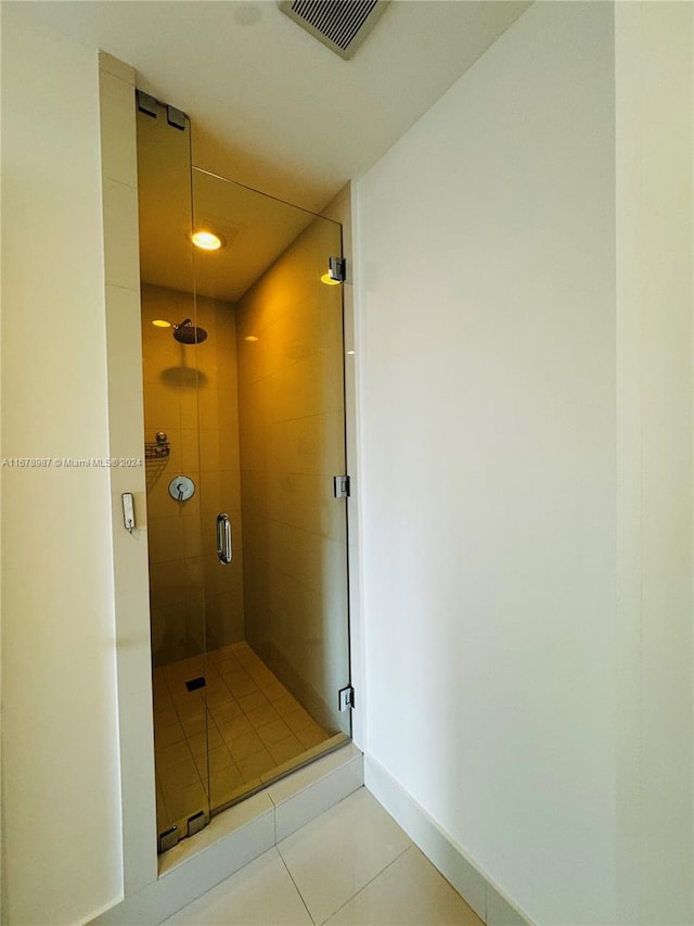 bathroom featuring a shower with door and tile patterned flooring