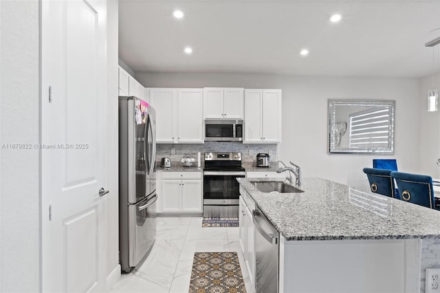 kitchen featuring appliances with stainless steel finishes, light stone countertops, sink, and white cabinets