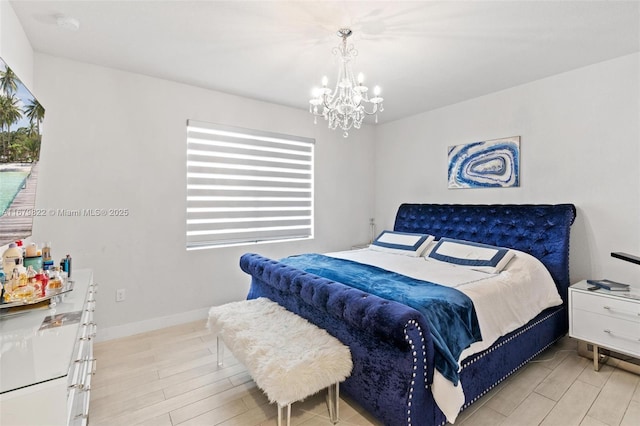 bedroom with an inviting chandelier and light hardwood / wood-style flooring