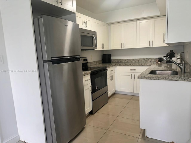 kitchen featuring white cabinets, light stone counters, light tile patterned floors, sink, and stainless steel appliances