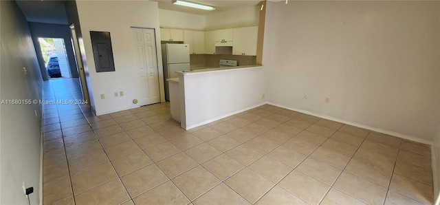 kitchen with electric panel, kitchen peninsula, white cabinets, light tile patterned floors, and white refrigerator