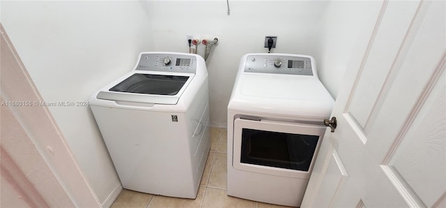 clothes washing area featuring light tile patterned flooring and washing machine and clothes dryer